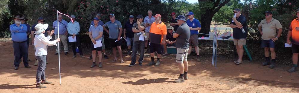 Alison MacGregor (consultant) overviewing the use of flagging tape on poles to follow the air flow of a sprayer at the Sunraysia workshop.
